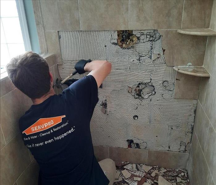 SERVPRO technician demolishes unsalvageable, moldy tile and adhesive on an exterior shower wall