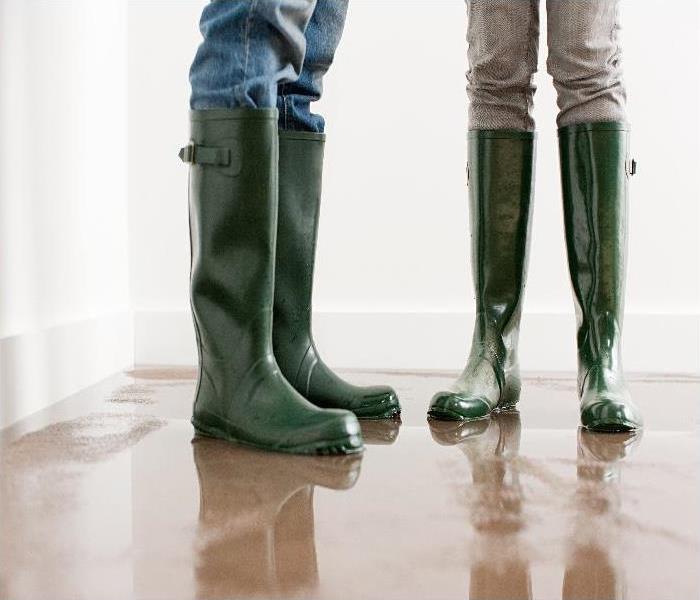 couple in wellington boots on flooded floor