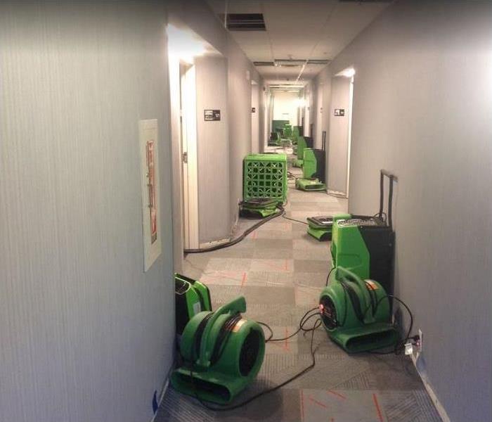 SERVPRO drying equipment being used in commercial property water damaged hallway
