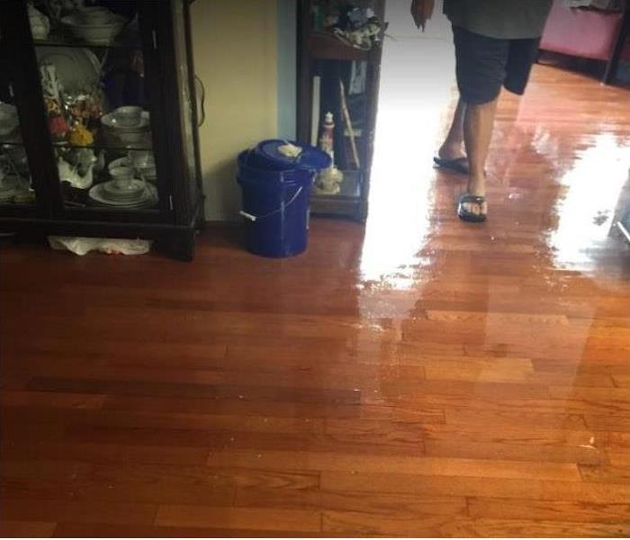 person walking in water damaged home; standing water on floor